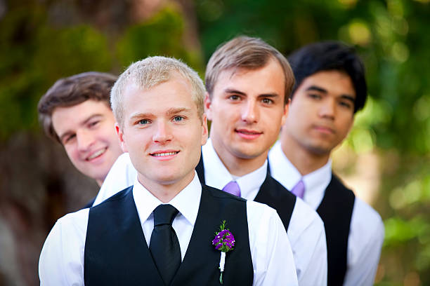 istock Groomsmen peeking from behind groom, outdoor 489951564