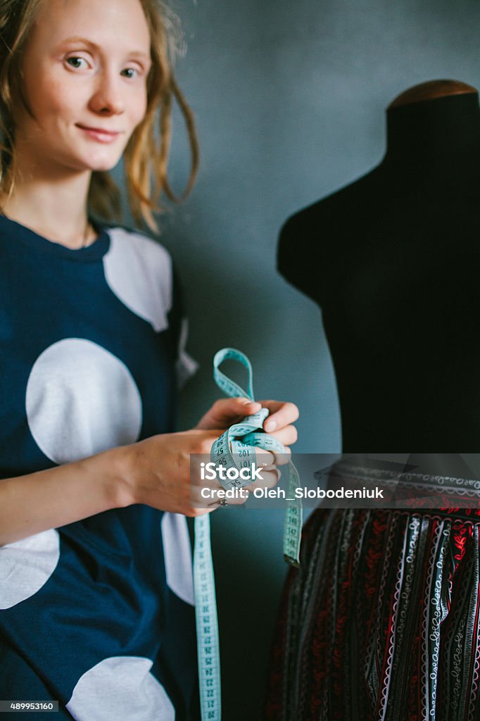 Tailor with flexible tape measure Tailor measuring with flexible tape  20-24 Years Stock Photo
