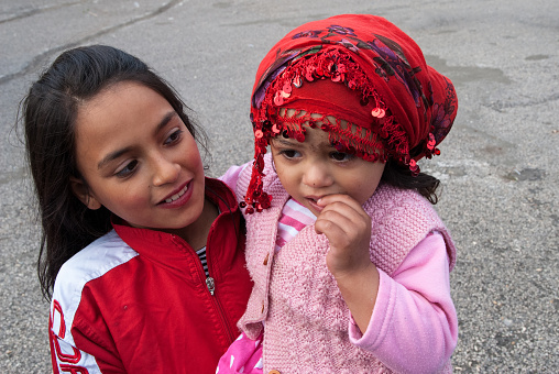 Edirne, Turkey - May 5, 2014: An unidentified gypsy girl holds her little sister during the international festival of Kakava. 