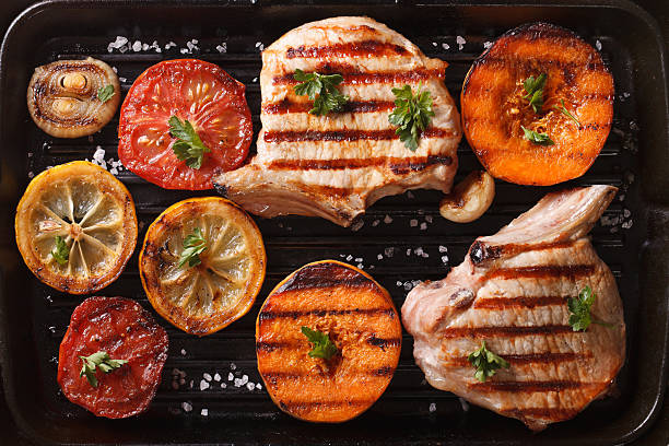 istock Grilled pork and vegetables on grill pan. top view horizonta 489955032
