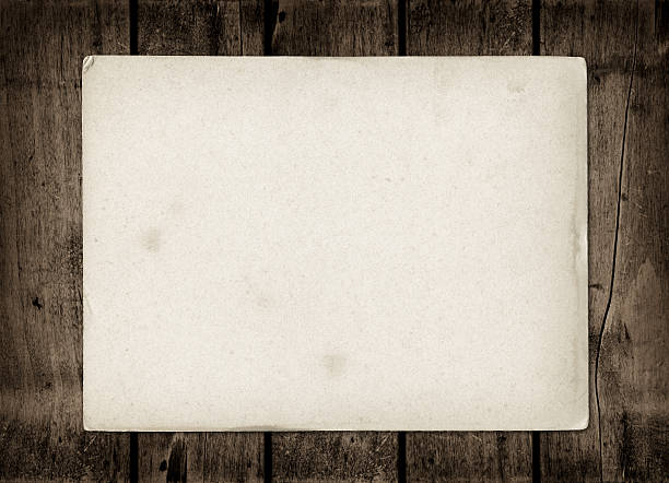 istock Old textured paper sheet on a dark wood table 489956538