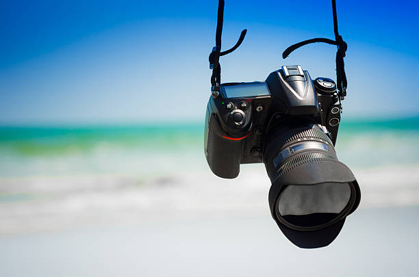 istock DSLR camera hanging at  the beach scenery 489957740