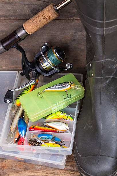 istock fishing tackles and rubber boots on timber board 489961390