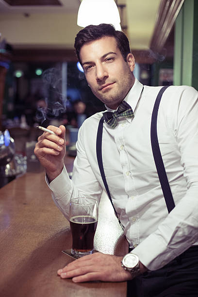 istock Elegant young man sitting at a bar 489970135