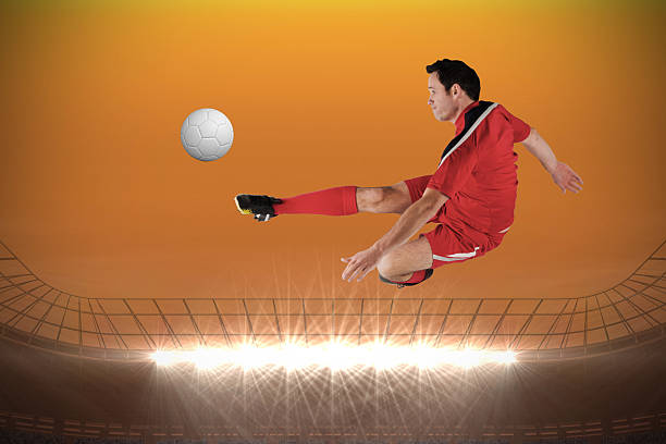 istock Football player in red kicking 489972397