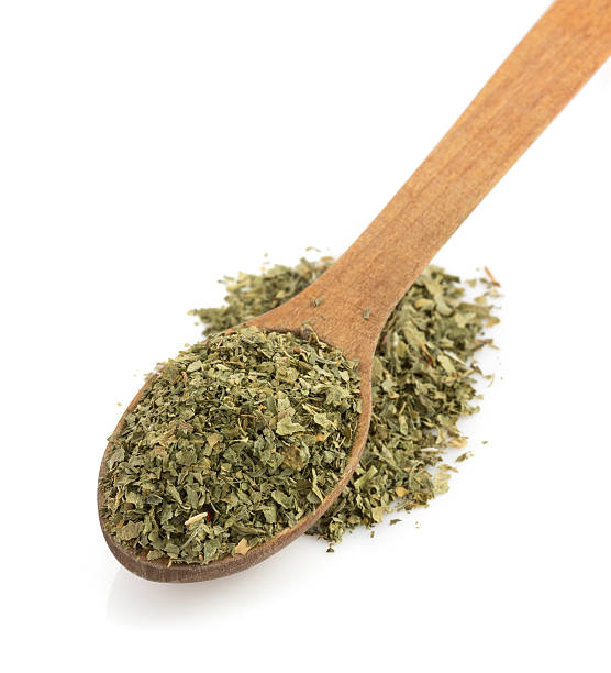 istock dried green spices and spoon on white 489975315