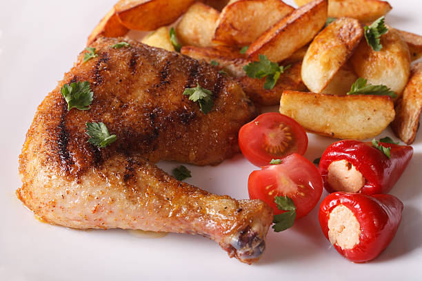 istock Grilled chicken thighs, fried potatoes and vegetables closeup. 489975376