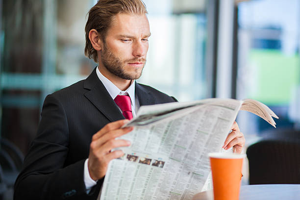 istock Handsome man with newspaper and coffee 489975932