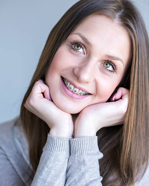 istock Smiling young woman with braces 489977582