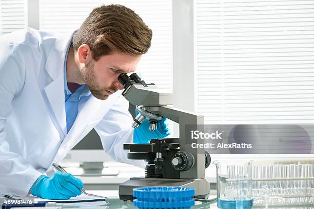 Scientist Looking Through A Microscope Stock Photo - Download Image Now - Microscope, Research, Scientist