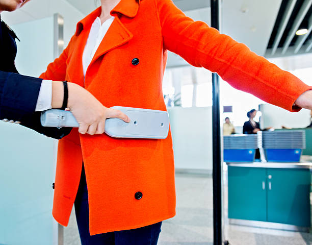 airport security check airport security check using a metal detector on a passenger. metal detector security stock pictures, royalty-free photos & images
