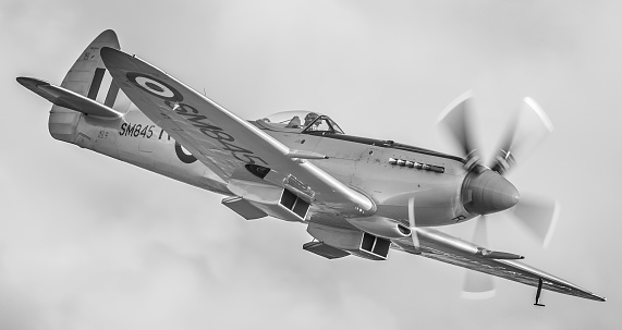 Duxford, UK - September 20, 2015: a Spitfire Mk. XVIII fighter aircraft of the mid to late 1940s pictured in flight over Cambridgeshire, England. 
