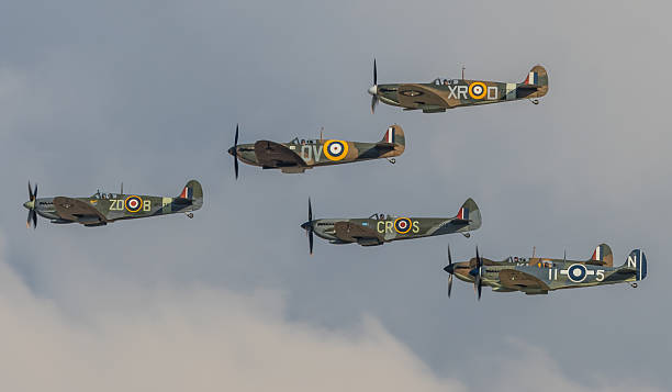 Spitfire formation flypast Duxford, UK - September 20, 2015: six Spitfire WWII fighter aircraft in a formation flypast over Cambridgeshire, England.  spitfire stock pictures, royalty-free photos & images