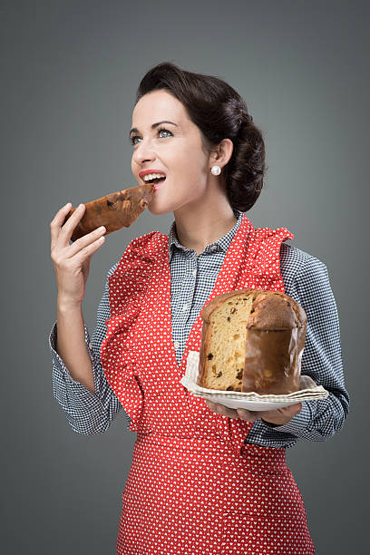 istock Woman in apron eating panettone 489986380