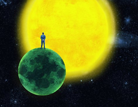 Businessman standing on the planet in front of the sun