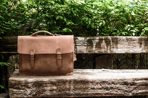 Brown Leather laptop bag corporate  on old wooden chair