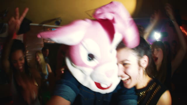 Guy with a bunny head with friends at party