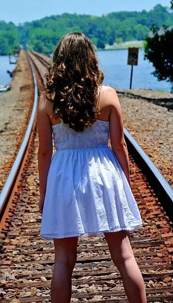 A girl standing on train tracks
