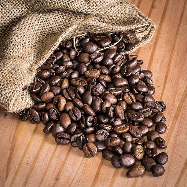 Coffee beans in bag over a wood table stock photo