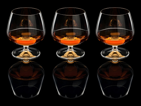 Three glasses with cognac it is isolated on the black