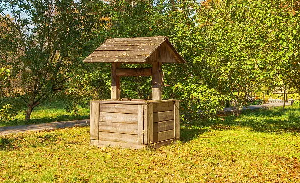 The old wooden well in the autumn garden