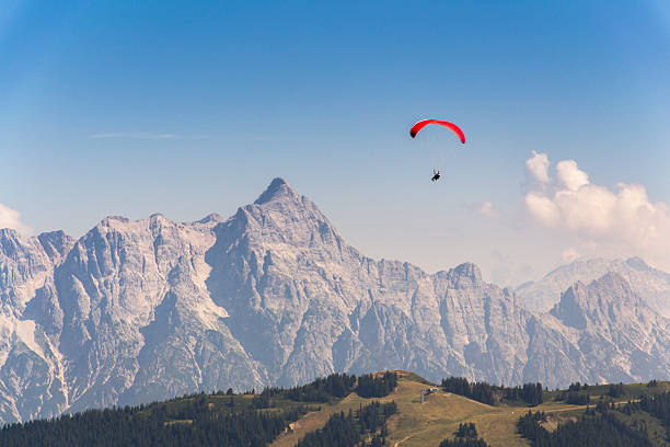 paraglider flyes sobre las montañas en los alpes, austria - paragliding sport austria parachuting fotografías e imágenes de stock