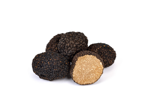 Black autumn truffles from France on a white background - tuber uncinatum