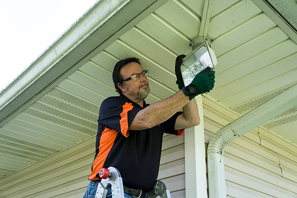 istock Electrician Changing A Bulb In A Outside Light Fixture 490023842
