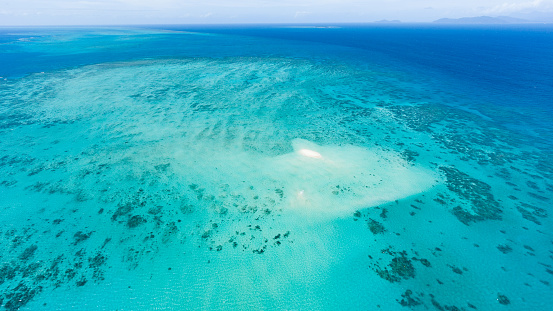 Aerial view of Great Barrier Reef, coral sand cay beach and clear blue water from helicopter, Queensland, Australia