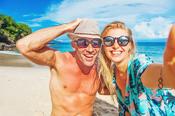 ﾀｯｷｴ 커플입니다 미소 및 껴안기 백그라운드 열대 해변 - australia photographing camera beach 뉴스 사진 이미지