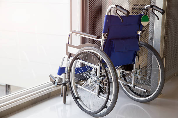 sedia a rotelle vuota parcheggiate in aeroporto - disablement foto e immagini stock