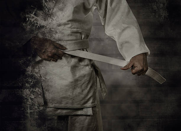 karateka apertar o cinto (obi) branco com fundo grunge - obi sash fotos imagens e fotografias de stock