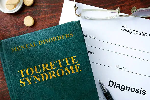 Tourette syndrome  concept. Diagnostic form and book on a table.
