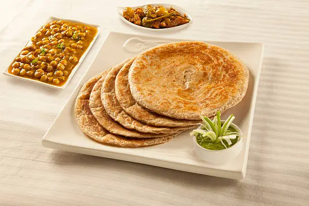 Bran paratha puri served with chickpeas cholay and pickle chutney