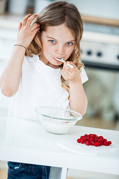 istock Young girl eating muesli with raspberries 490052748