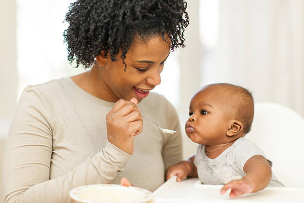 フィーディング赤ちゃん - baby eating child mother ストックフォトと画像