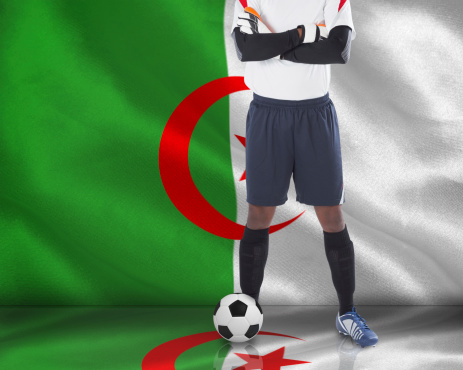 Composite image of goalkeeper in white with ball against algerian flag