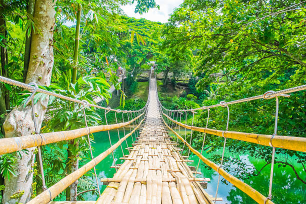 istock Bamboo pedestrian suspension bridge over river 490068055