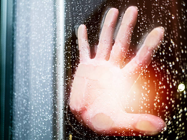 istock Hands on the wet, rainy glass door 490069053