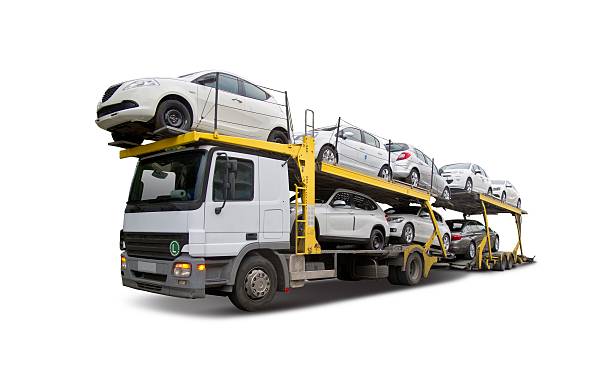 a white truck transporting multiple vehicles