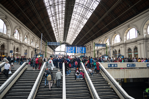 London, UK - Jun 6, 2023: People buying train tickets from a self-service machine inside Victoria train station, one of the busiest railway stations in London, UK