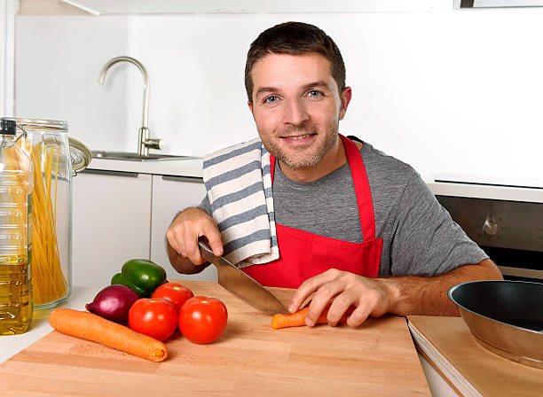 istock home cook man slicing carrot with kitchen knife happy 490075944