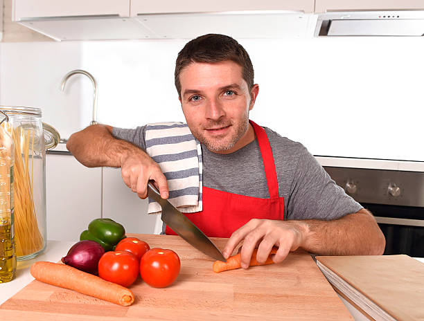 istock home cook man slicing carrot with kitchen knife happy 490076116
