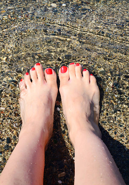 Mujer cuadrados con rojo pedicura relajante en agua - foto de stock