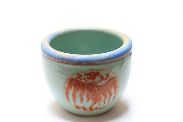 Qing (Ch'ing) Dynasty light green porcelain bowl with orange dragon design. The bowl is from circa 1850, with a white background and plenty of copy space.