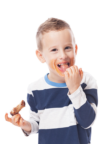 Adorable kid eating bbq ribs on isolated white
