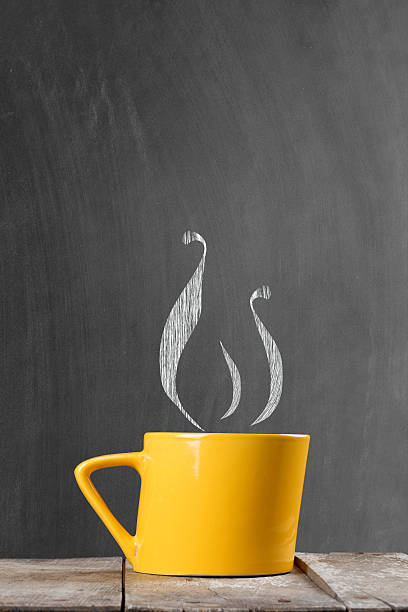 istock Steaming yellow coffee cup in front of blackboard 490084302
