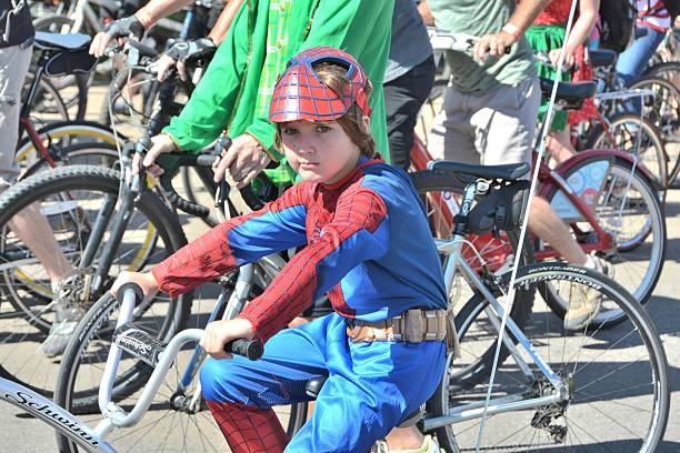 young boy on bicycle - spider man stockfoto's en -beelden