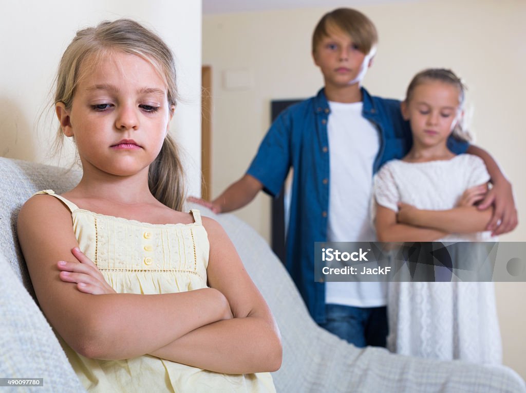 First amorousness:  girl and couple of kids apart First amorousness: sad russian girl and couple of kids apart indoors Boys Stock Photo
