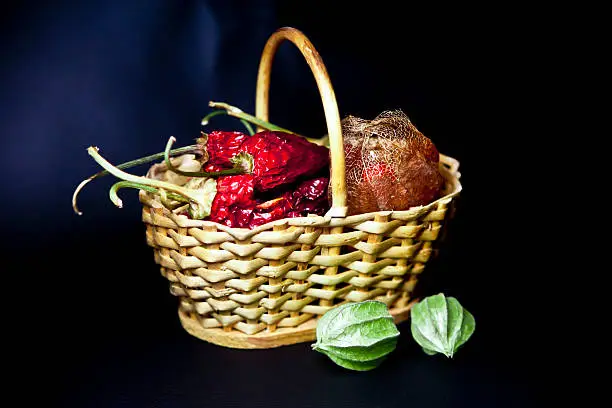 basket with dry red chili peppers and Cape gooseberry peel